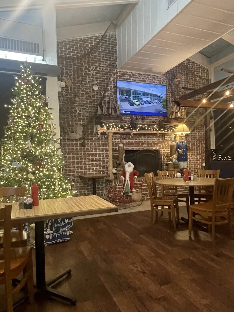 The Mayflower dining room — brick fireplace, high ceilings, wood tables