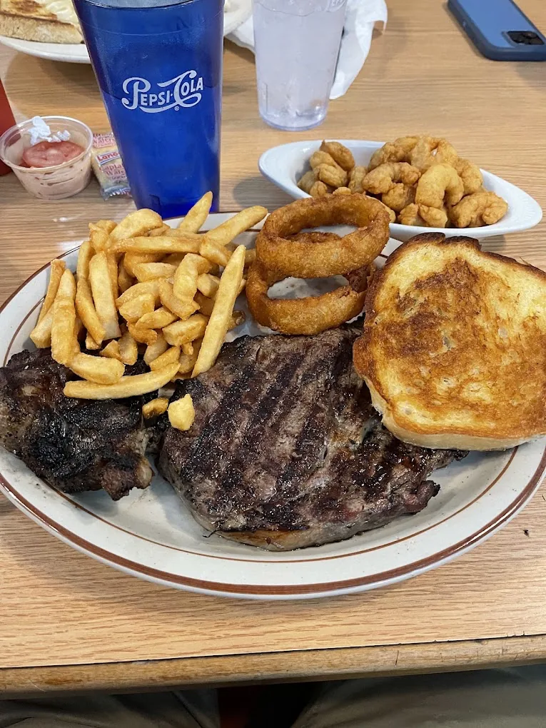 Grilled ribeye with fries, onion rings, garlic toast, and a side of shrimp