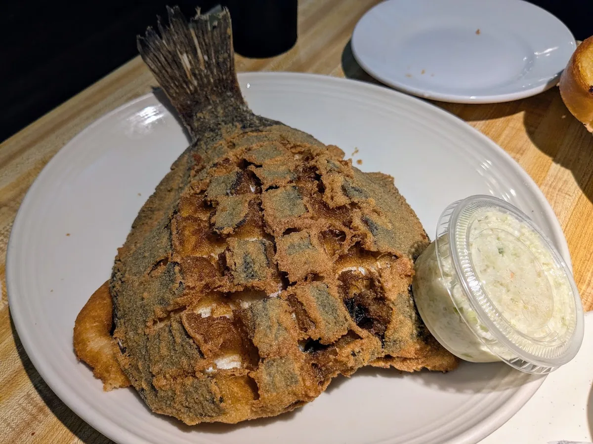 Whole fried flounder, scored and cornmeal-crusted, with a cup of slaw